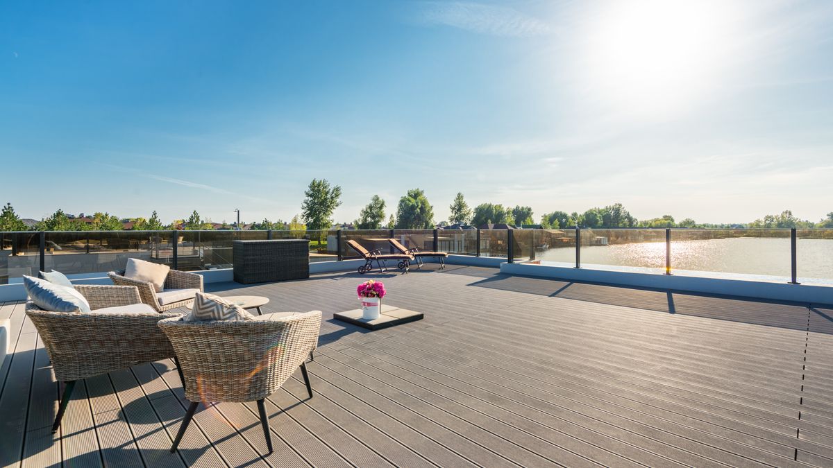 Terrasse en bois exotique avec chaises longues au bord d'une piscine