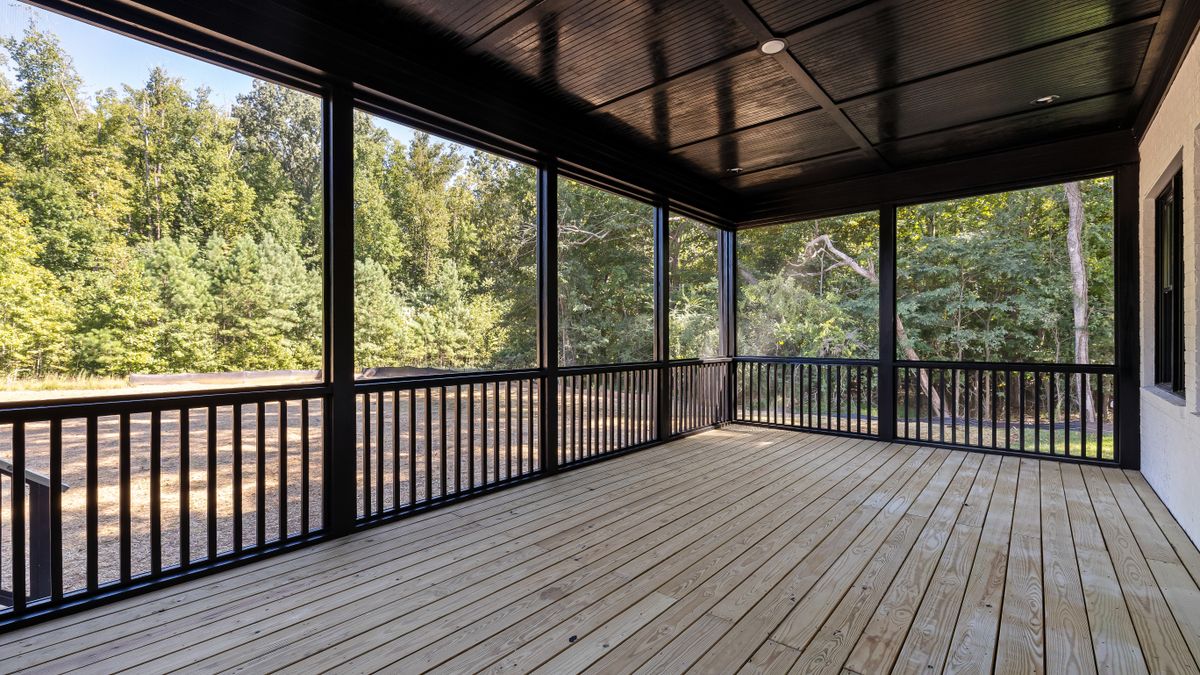 Grande terrasse en bois entourée d'un jardin arboré